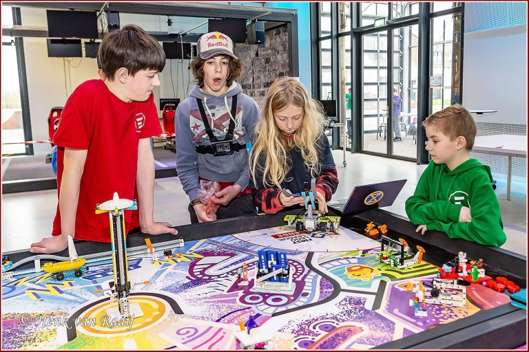 Op deze afbeelding zie je vier kinderen rondom First Lego League