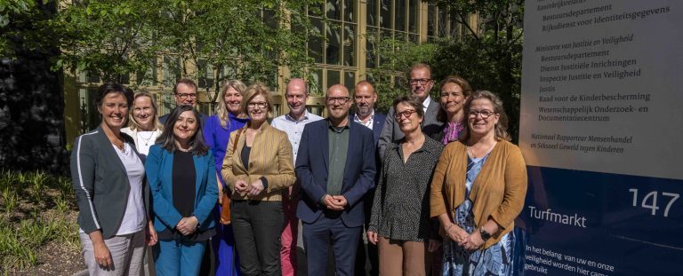 een groep medewerkers van het ministerie en boardleden van 8rhk bij elkaar in een groepsfoto